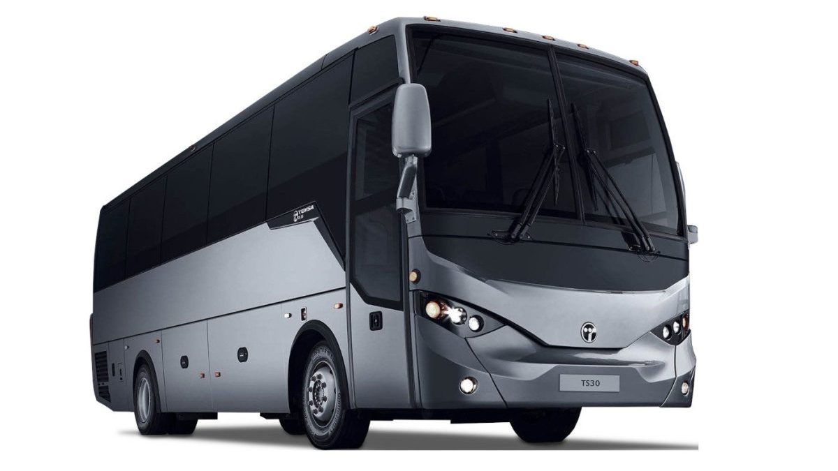 A silver and black coach bus with tinted windows is parked on a white background, viewed from the front left side.
